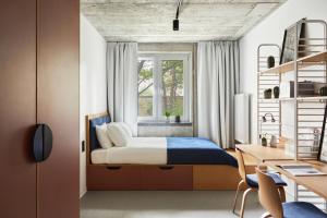 罗兹Chill Inn的一间卧室配有一张床、一张书桌和一个窗户。