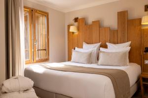 卡普费雷Domaine du Ferret Restaurant & Spa的卧室设有一张白色大床和一扇窗户。