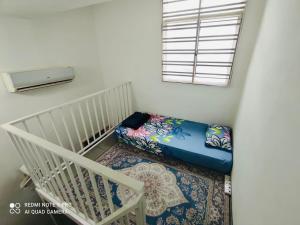 马六甲Alleysya's Homestay的一间设有婴儿床和豆袋的房间