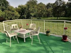 萨拉热窝Villa Nora Garden的露台配有三把椅子和一张桌子