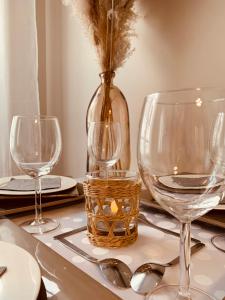 马尼库尔勒翁格尔NatySweethome的一张桌子,上面有三杯酒和花瓶