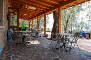 布雷佐内加尔达Agricampeggio Paradiso的石头地板上带桌椅的庭院