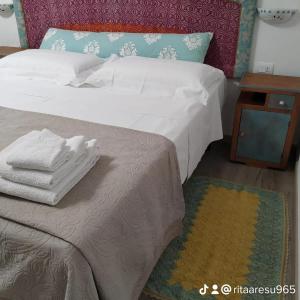 拉努塞伊B&B SA CROBE的一间卧室配有一张带白色床单和一张桌子的床。