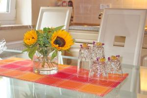 吕本瑙Ferienhaus Herz的一张桌子,上面有花瓶,上面有向日葵