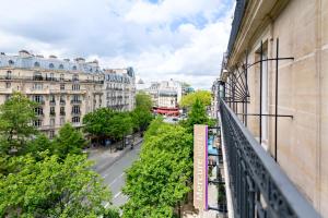 巴黎巴黎蒙帕纳斯拉斯帕伊美居酒店的阳台享有街道和建筑的景致。