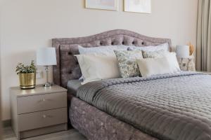 希奥利艾E.D. Luxury Apartaments的卧室配有带枕头和床头柜的灰色床。