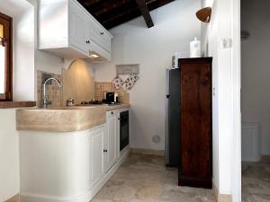 圣温琴佐Casa PÀTHOS的厨房配有白色橱柜和黑色冰箱。