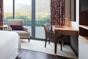 科莫科莫湖喜来登酒店的酒店客房设有一张书桌和一个大窗户。