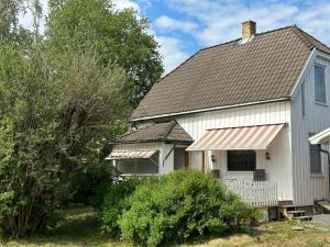 利勒斯特罗姆Oslo House, Nedre Kjellerstuvei, First floor, Twin Room的白色的房子,有棕色的屋顶和树木