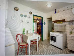 维拉皮亚纳Casa Patrizia的厨房配有桌子、两把椅子和炉灶。