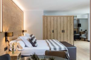 安道尔城阿克塔艺术酒店的一间卧室配有一张床和一扇木门