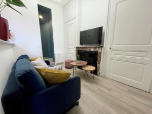 里昂Luxury Apartment "Le Raffiné" - Lyon Part-Dieu - Dreamy Flat Lyon的客厅设有蓝色的沙发和壁炉