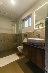 阿伯来Eerus Villa 3Bhk Luxurious Home的一间带水槽、卫生间和玻璃淋浴间的浴室