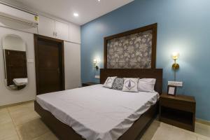 阿伯来Eerus Villa 3Bhk Luxurious Home的一间卧室设有一张大床和蓝色的墙壁