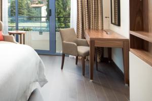 科莫科莫湖喜来登酒店的一间卧室配有书桌、床和窗户。
