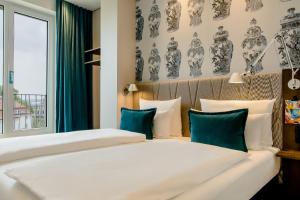 德累斯顿德累斯顿茨温格汽车旅馆的一间卧室配有两张带蓝白色枕头的床