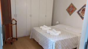 特拉帕尼A Casa di Clara的小房间设有两张床和一张带白色床单的桌子