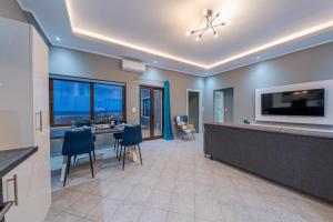 科林瓦里奥Luxury Sea View Apartment in Kolimvari的一间大房间,设有厨房和一个带电视的酒吧