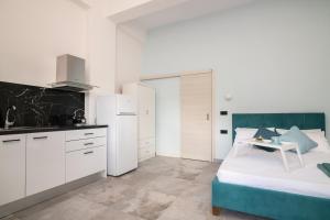 扎金索斯镇Nostalgia Apartments Zante的一间厨房,配有白色的橱柜和一张位于客房内的床