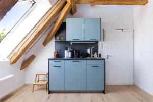 达豪limehome Dachau Konrad-Adenauer-Str的厨房配有蓝色橱柜和冰箱。