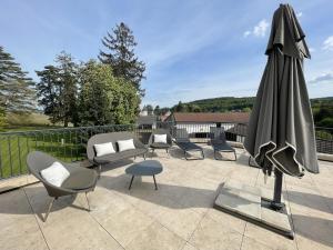 萨维尼莱博恩Manoir de Villamont的庭院配有遮阳伞、椅子和桌子。