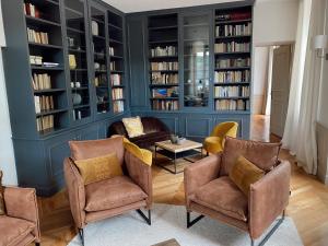 萨维尼莱博恩Manoir de Villamont的客厅配有椅子和书架