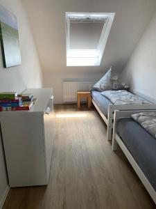 OsteelLandhaus "Alte Welt" Nordseeküste的一间卧室配有一张床、一张书桌和一个窗户。