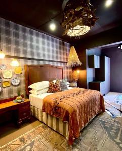 汉诺威The Hanover Luxury Hotel的一间卧室配有一张床、一张桌子和一个吊灯。