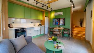 卡尔坎Pier House Hotel的厨房配有绿色橱柜、沙发和桌子