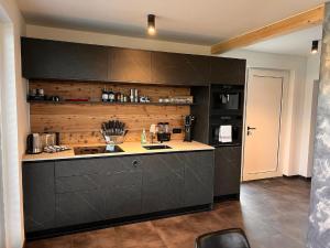 弗赖翁Chalet Deluxe的厨房配有黑色橱柜和台面