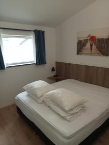 乌得勒支Domstad Resort Utrecht Vakantiewoningen的一间卧室配有一张带白色床单的床和一扇窗户。