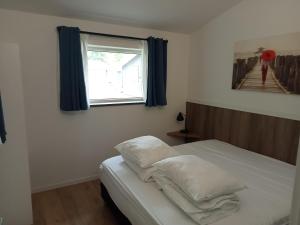 乌得勒支Domstad Resort Utrecht Vakantiewoningen的卧室配有带白色枕头的床和窗户。