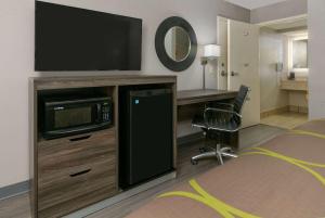 比洛克西比洛克西/ 戴博维勒速8酒店的配有电视、书桌和床的房间