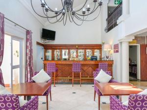 约翰内斯堡约翰内斯堡兰德堡美居酒店的一间用餐室,配有紫色椅子和一张桌子