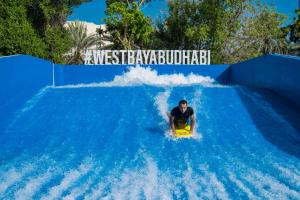 阿布扎比Radisson Blu Hotel & Resort, Abu Dhabi Corniche的水滑梯上挥手的人
