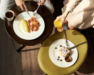 布卡拉顿博卡拉顿万丽酒店 的两人坐在餐桌上,一边吃盘子