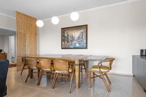 埃斯托利尔Cascais by the Sea的一间带木桌和椅子的用餐室