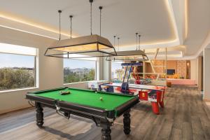 西隆Courtyard by Marriott Shillong的一间带台球桌的房间和一个带窗户的游戏室