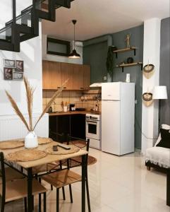 普洛马里翁Io the cosy home Plomari的厨房配有桌子和白色冰箱。
