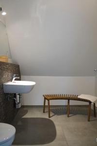 沃尔夫斯堡Charmantes Apartment in Top Lage的一间带卫生间、水槽和长凳的浴室