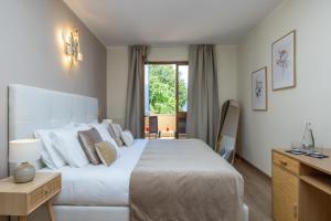 加尔尼亚诺Hotel Meandro - Lake View的卧室设有一张白色大床和一扇窗户。
