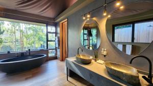 Reebok波特里尔斯科普私人野生动物保护区酒店的浴室设有2个水槽、浴缸和镜子