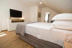 波达卡Apartment Navis的卧室配有一张白色大床和电视。