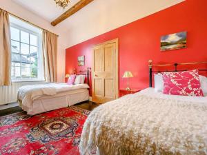 凯西克Oak Lodge的红色卧室设有两张床和窗户