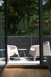 格拉茨Arbio I Urbanstay Serviced Studios & Apartments的庭院里设有两把白色的椅子和一张桌子