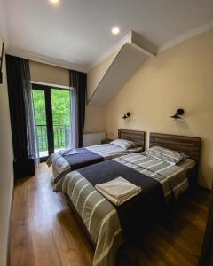 卡兹贝吉Hotel Gold Kazbegi的一间卧室设有两张床和大窗户