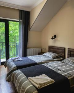 卡兹贝吉Hotel Gold Kazbegi的带窗户的客房内的两张床