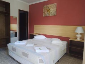 乌巴图巴Hotel Venice Ubatuba的卧室配有白色的床铺和红色的墙壁