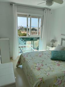 维拉Ático con piscina privada vistas al mar.的一间卧室设有一张床和一个大窗户