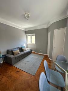 里斯本Rooms to rent in a friendly apartment的带沙发和玻璃桌的客厅
